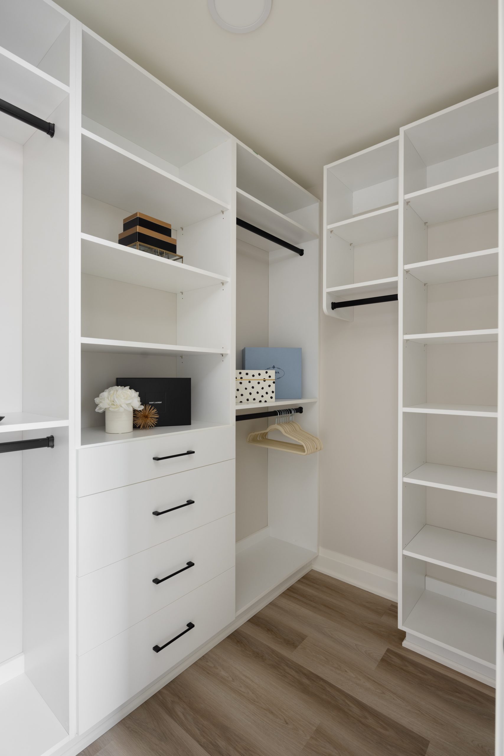 walk-in closet featuring lots of storage in white cabinets.